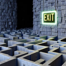 A complex labyrinth with a glowing exit sign symbo